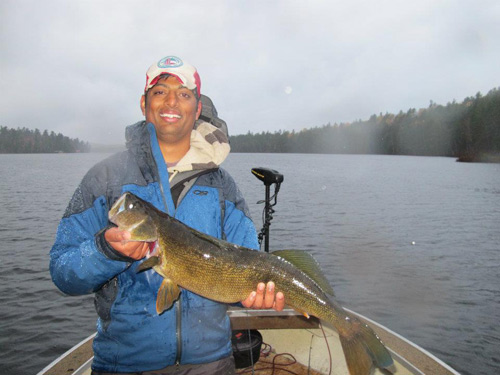 Man on adirondack lake holding large fish