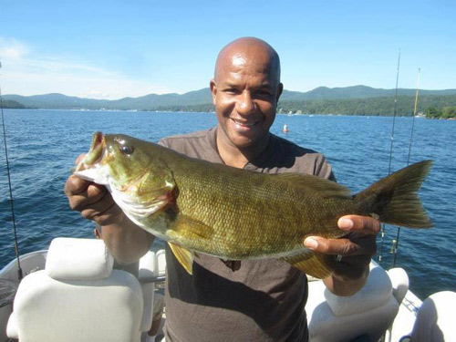 Man in boat on Lake George holding large fish