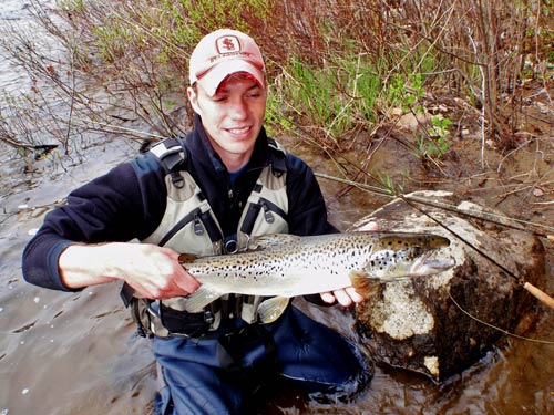 Main in waders holding large fish