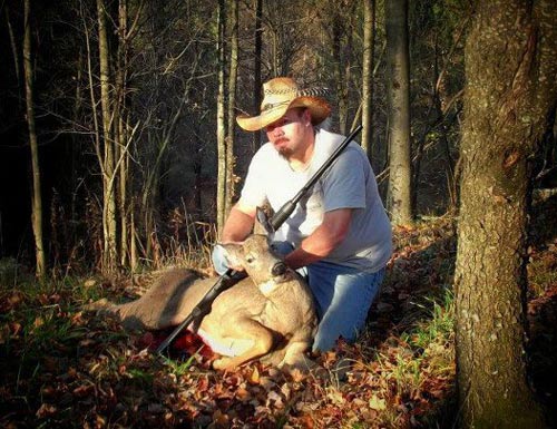 Hunter in fall leaves with smaller white-tailed deer