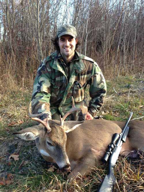 Hunter in camaflouge with young buck and rifle