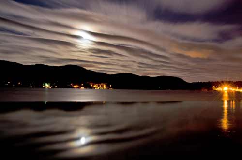 full moon rising on a cloudy evening over lake george