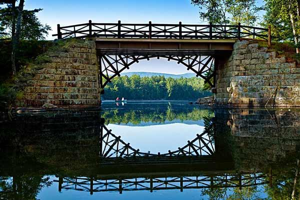 Old stone bridge over still water