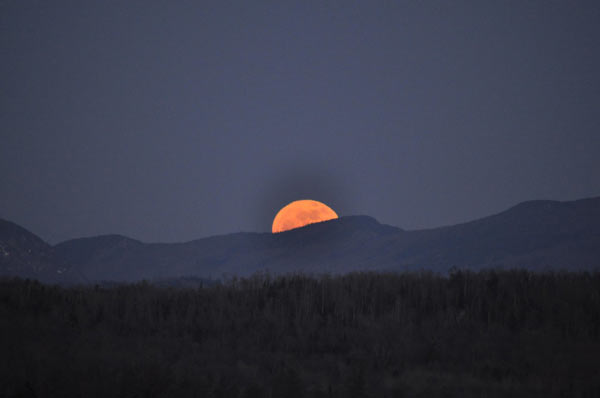 Golden moon rises over Mountain ridge