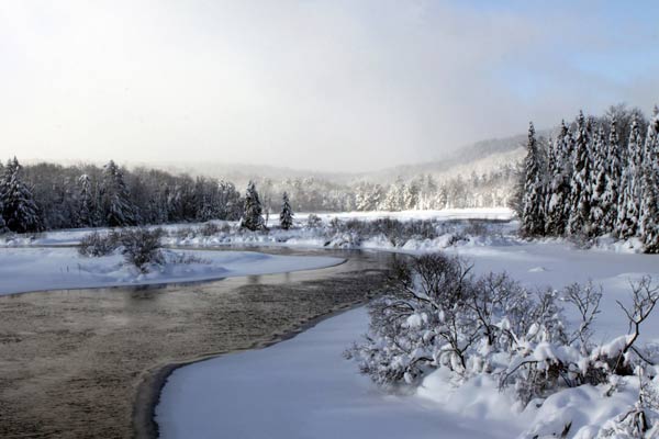 Snowy landscape surrounds a river