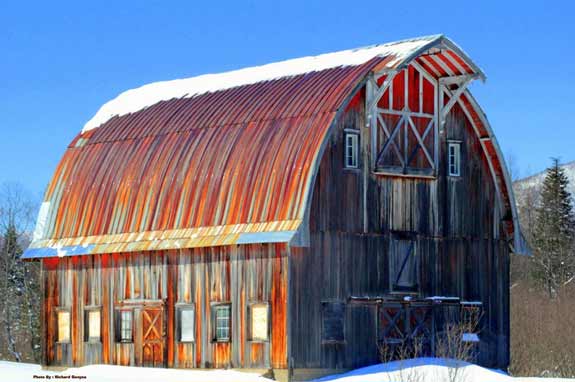 Weathered red and grey barn in winter