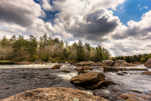 rocky river lined with trees