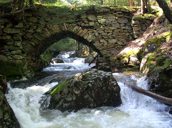 Rushing waters under a stone bridge