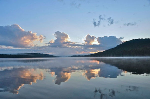 Clouds reflecting on Raquette Lake in the early morning