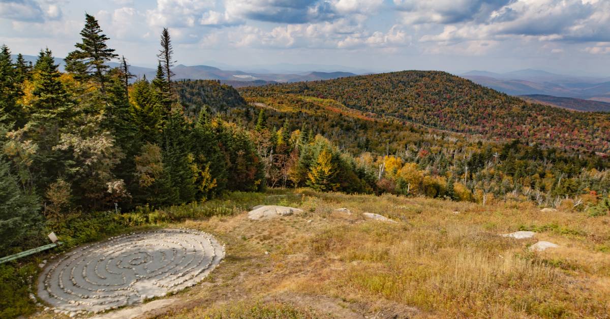 overhead view of a stone labyrinth and fall colors on trees and mountains