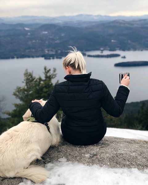 golden retriever and woman on mountain summit