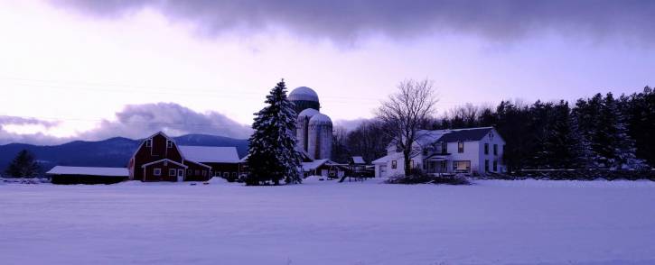 House and farm covered in snow & distant mountains