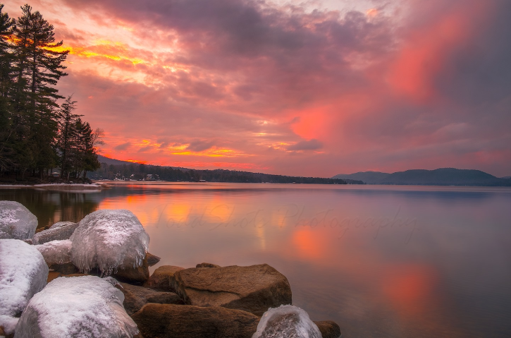 Vibrant pink sunset over a lake during the winter