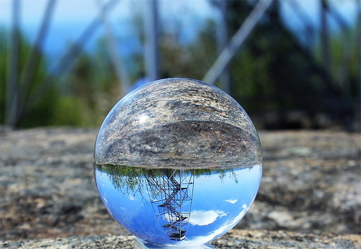 fire tower reflected in glass ball