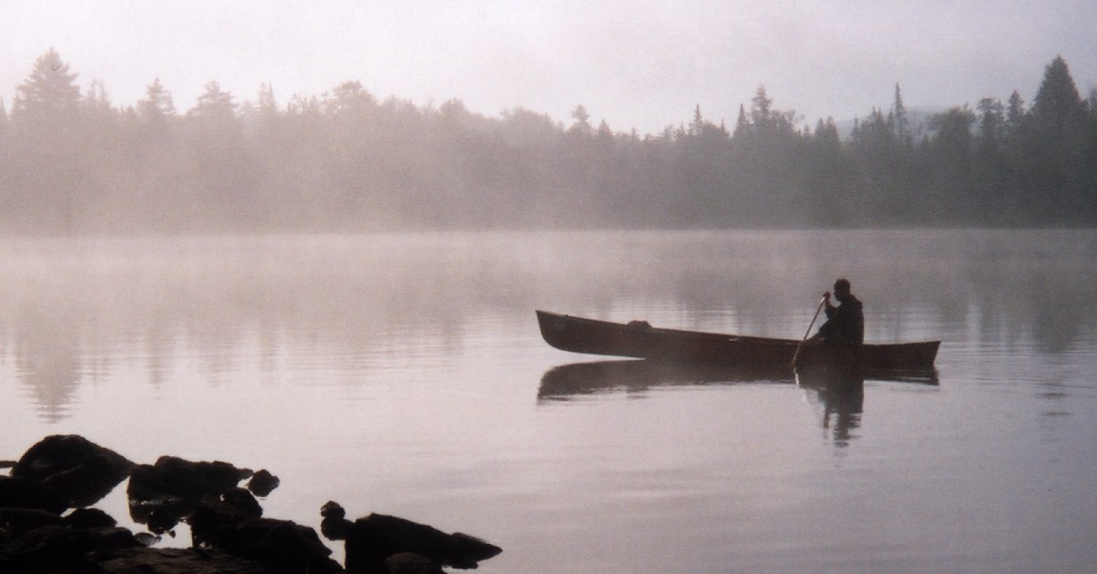 a canoe on a misty pond