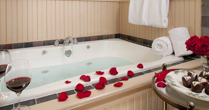 rose petals and wine near a jacuzzi tub