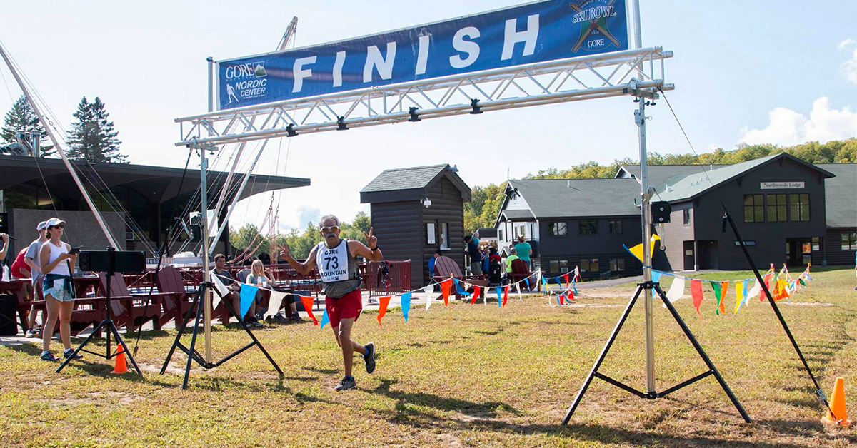 man crossing the finish line of a running race