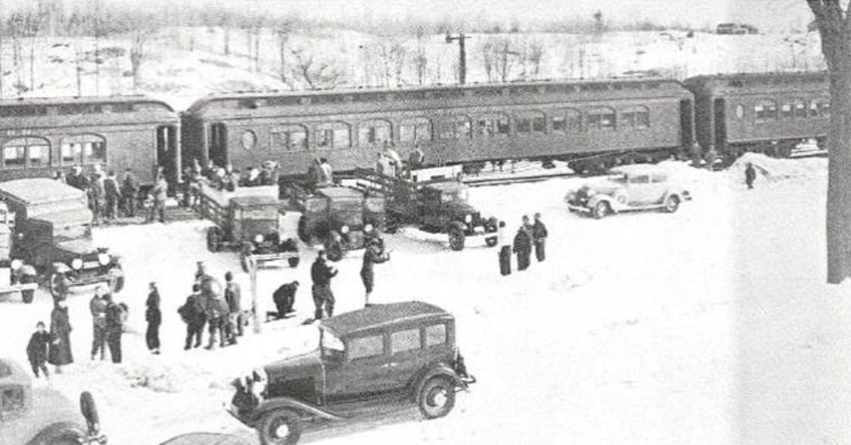 black and white image of people outside a train in winter