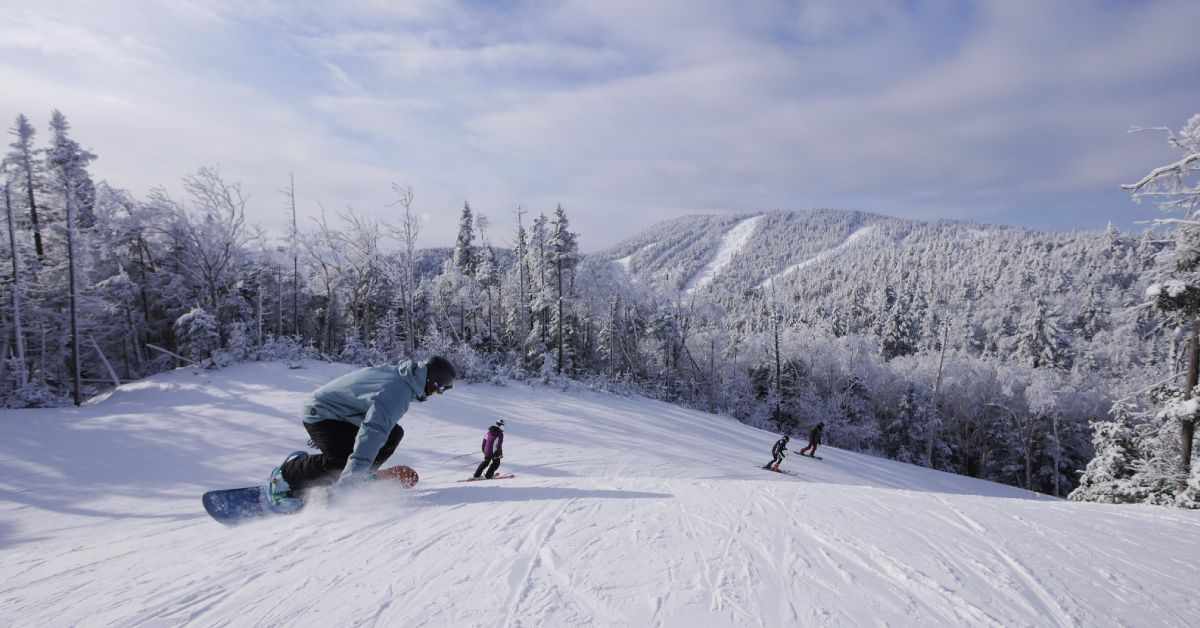 people skiing and snowboarding down a snowy mountain