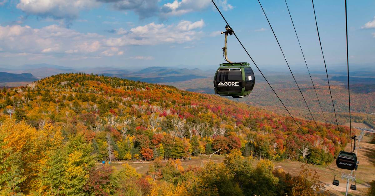 a gondola at a ski resort with fall colors on the trees