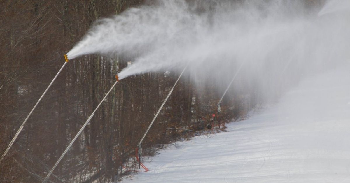 snowmaking machines blowing snow onto trails