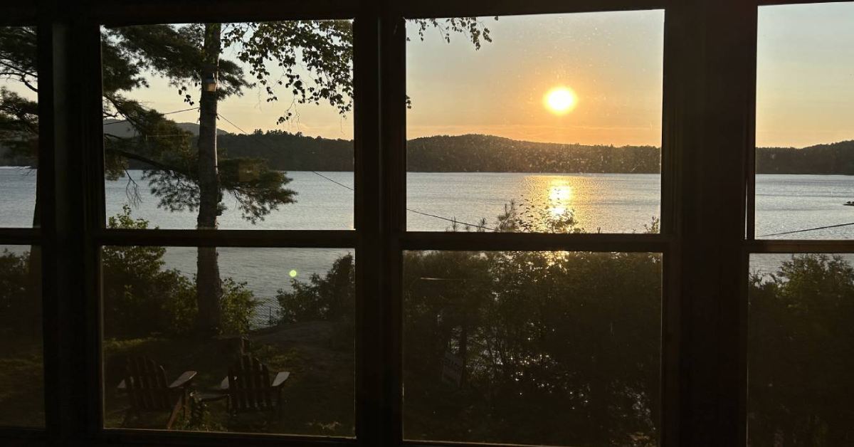 view of a sunset from the window of a hotel facing a lake