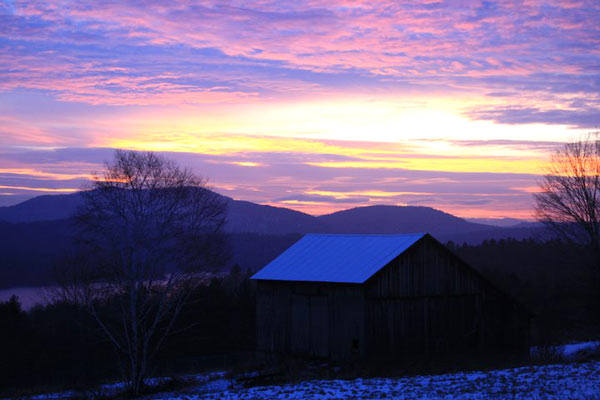 Barn overlooking mountains during sunrise