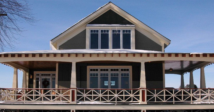 green bed and breakfast with wrap-around porch in winter