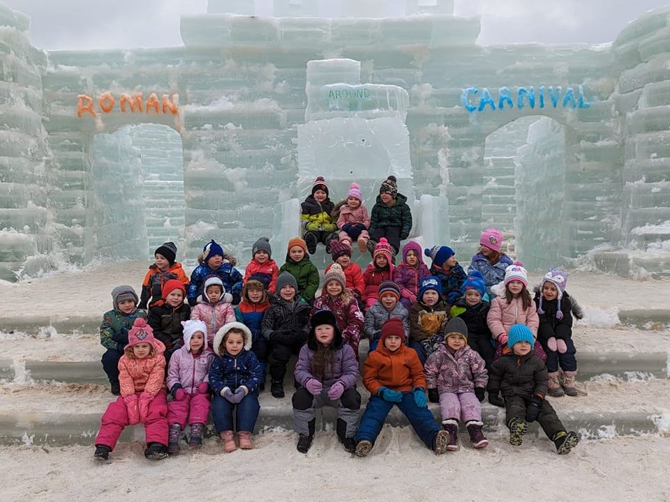 group of kids pose in front of the palace