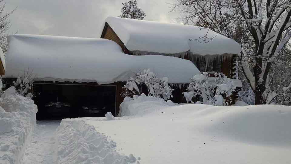 snow on top of a house and garage